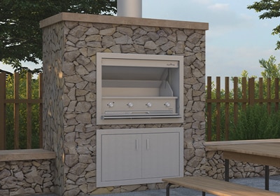 Freestanding stone-clad outdoor cooking unit with stainless steel burners, flue and storage cupboard below, set in a fenced garden