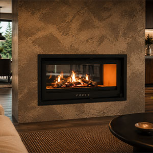 Forge I D100 double-sided built-in fireplace set into textured stone wall beside black side table